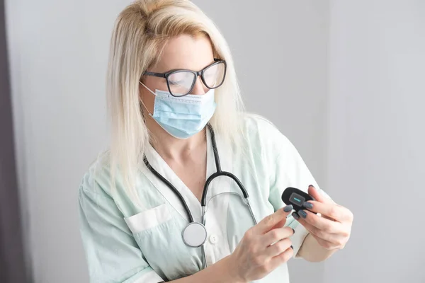 Женщина-врач держит пальцевой пульсометр — стоковое фото