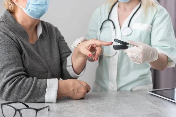 Arzt untersucht Patient mit Fingerkuppen-Pulsoximeter — Stockfoto