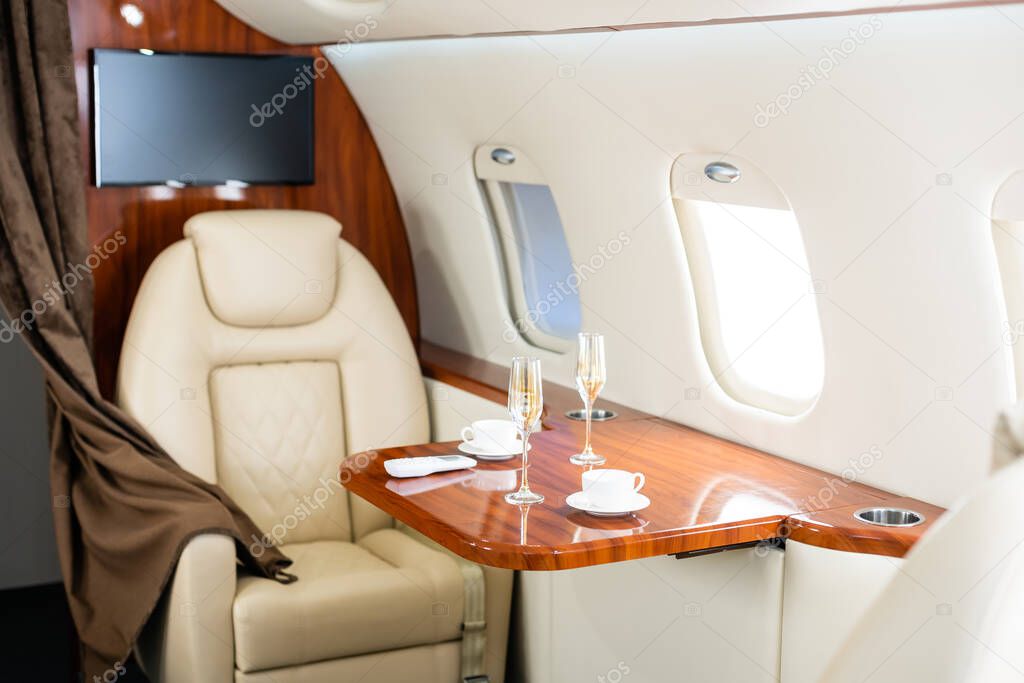 Cabin of luxury private jet. Empty aircraft with white leather chairs.