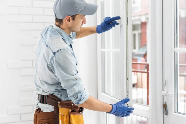 Trabajador de la construcción poniendo cinta de espuma de sellado en la ventana en casa —  Fotos de Stock