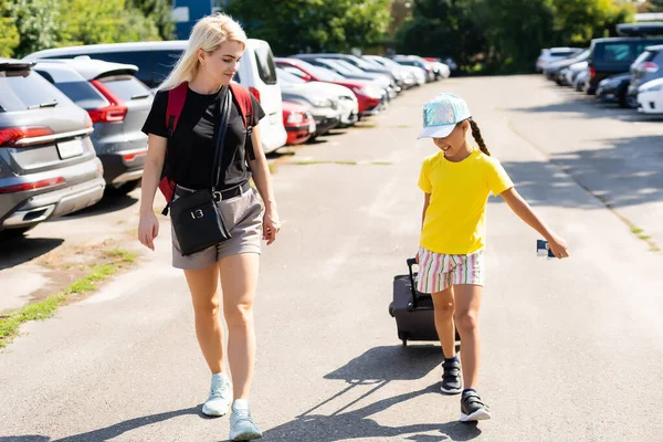 Mãe e filha com mala no estacionamento — Fotografia de Stock