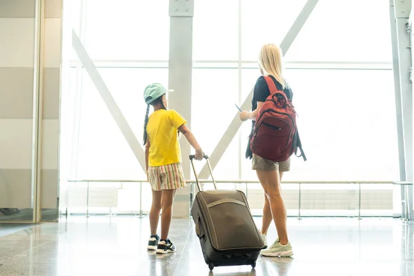 Madre e hija pequeña en la terminal del aeropuerto Imágenes de stock libres de derechos