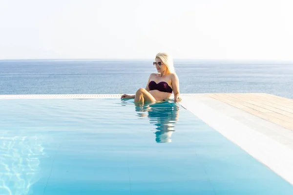 Lifestyle concept vacances d'été, les femmes en maillot de bain se détendre sur la piscine, jeune femme sexy en bikini près de la piscine. Vacances d'été, Voyage, les gens et les vacances concéder — Photo