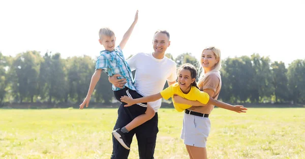 緑の野で遊ぶ幸せな家族は — ストック写真