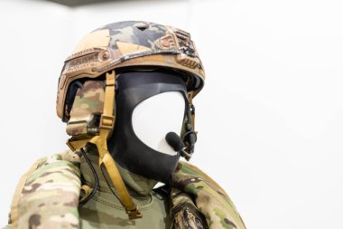 Askeri üniformalı ve teçhizatlı manken. Güvenlik kaskı ve gözlükleri. Özel telsiz iletişim cihazı. Modern savaş tesisleri.