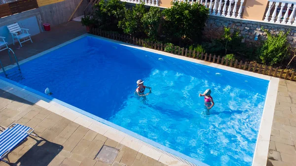 Madre e hija jugando en una piscina — Foto de Stock