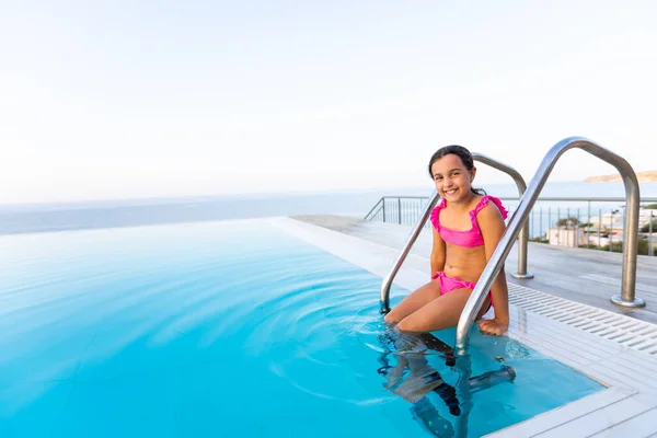 A kislány a játék jumping vízbe nyaralás szigeten tropical beach szabadtéri medencével várja vendégeit. Gyermek a tanulás luxus üdülőhely szabadtéri medence. — Stock Fotó