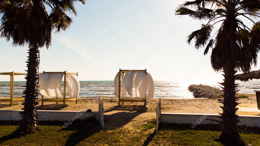 View to sandy beach of Adriatic Sea and to the city of Durres, Albania during sunset.