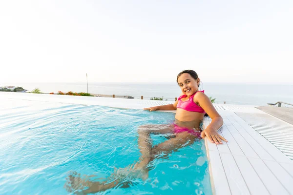 Retrato de cerca de la linda niña árabe nadando en la piscina, niño feliz divirtiéndose en el agua, resort de playa, vacaciones de verano y el concepto de vacaciones —  Fotos de Stock