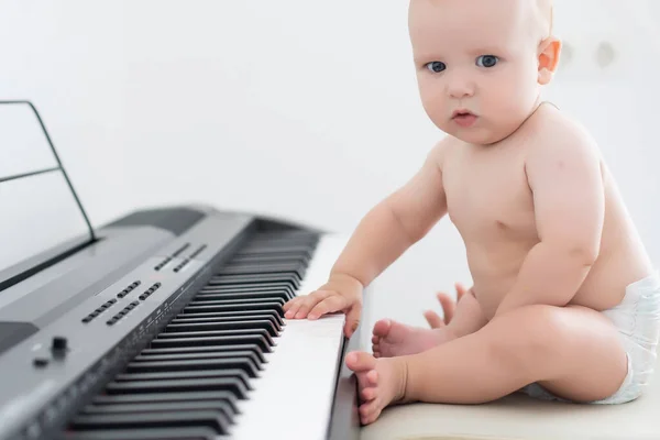 Child playing synthesizer on white background — Stockfoto