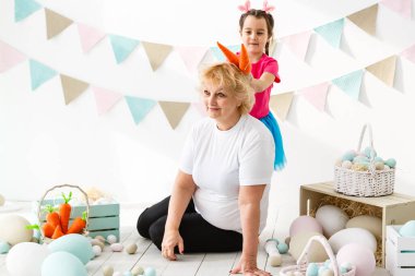 Paskalya konsepti. Mutlu küçük kız ve büyükanne Paskalya yumurtalarıyla