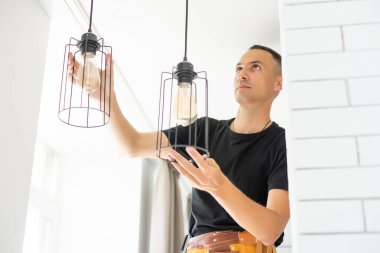 İçerideki tavan üzerinde lamba tamir eden işçiler