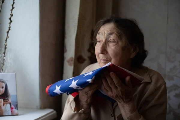 Старшая, которая гордится тем, что она американка, очень старая женщина с американским флагом. — стоковое фото