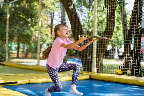 Menina pulando em um trampolim em um dia de verão — Fotografia de Stock