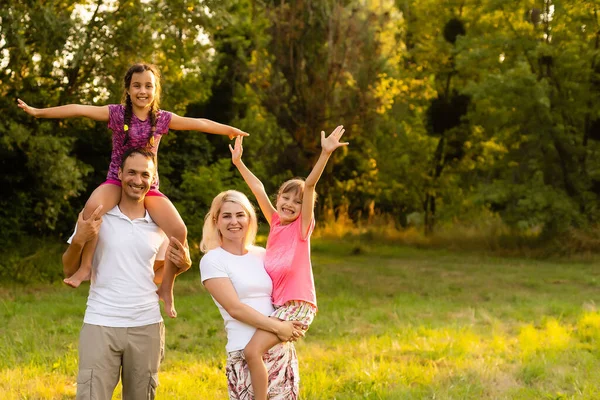 Boldog család élvezi az életet együtt rét szabadban. — Stock Fotó