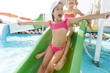 İki küçük kız havuza atlarken eğleniyor.