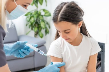 Doktor çocuk aşısı yapıyor.