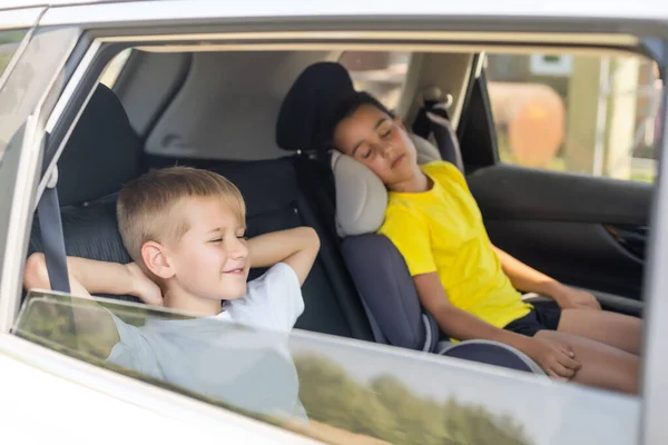 Leende barn sitter på baksätet i bilen — Stockfoto