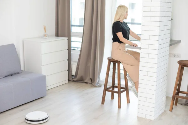 Modern life concept, woman relaxing , automatic robotic hoover clean the room while