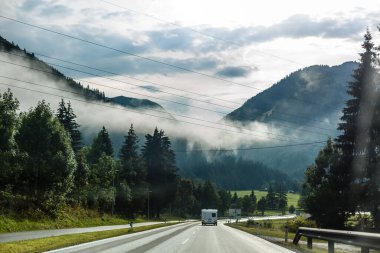 Dağlarda yollar dönüyor, Alpler arka planda.
