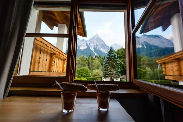 Two glasses and two rolls for breakfast by the window in the mountains — Stok fotoğraf