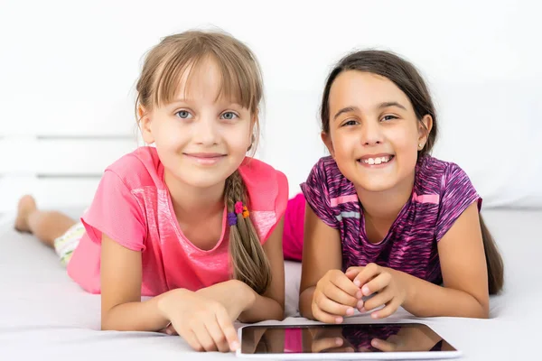 Pessoas, crianças, tecnologia, amigos e conceito de amizade meninas olhando para tablet pc computadores em casa — Fotografia de Stock
