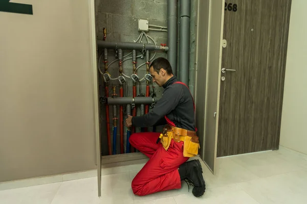 Bau-, Berufs- und Personenkonzept - Bau- oder Klempner arbeiten mit Wasserleitungen im Heizungsraum — Stockfoto