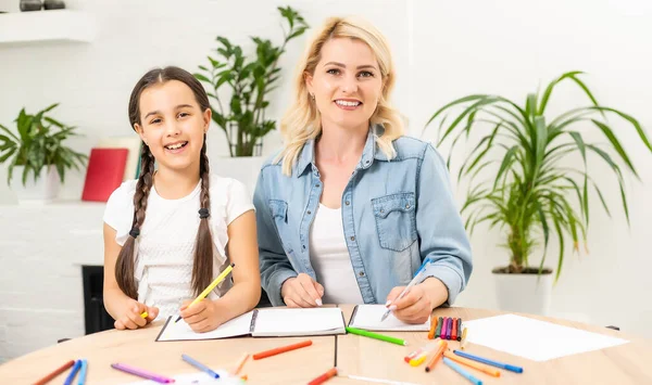 Moeder en dochter die tijd samen thuis doorbrengen met tekenen — Stockfoto