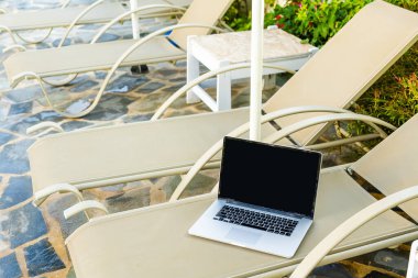 Havuz kenarında güneşlenen bir bilgisayarda.