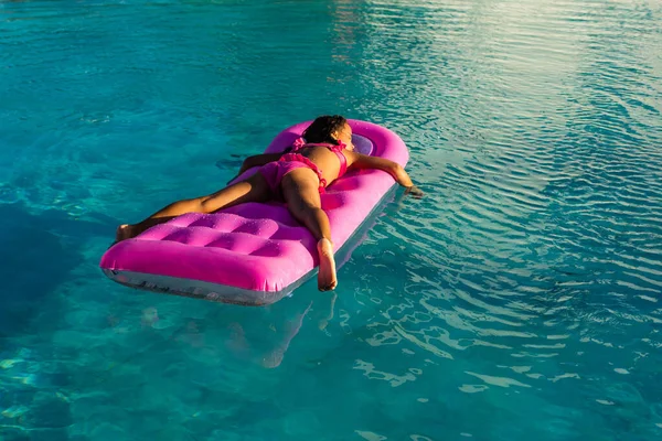 La ragazza si rilassa su un materasso gonfiabile in piscina, facendo bagni d'aria. — Foto Stock