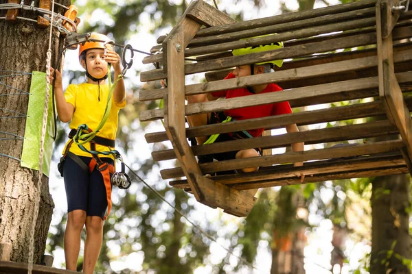 Lindos niños. Niño y niña escalando en una estructura de patio de cuerda en el parque de aventuras — Foto de Stock