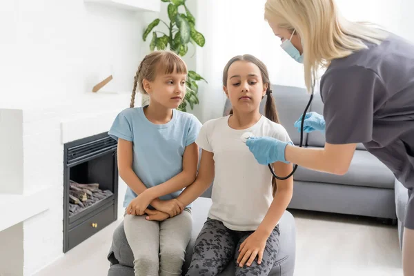 Jonge arts met kleine meisje patiënt voelt zich slecht medische inspectie met stethoscoop. — Stockfoto