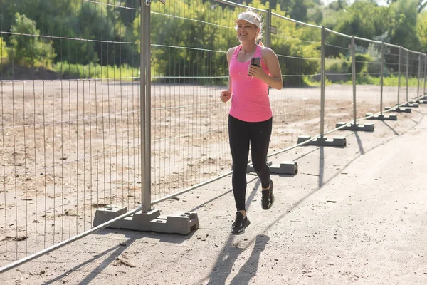 Donna in corsa. Corridore femminile che fa jogging durante gli allenamenti all'aperto in un parco. — Foto Stock