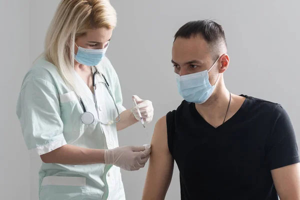 L'injection du vaccin COVID-19, le médecin en gants tient la seringue et fait du jab à la patiente en clinique. Prévention du coronavirus ou de la grippe. virus corona et vaccin antigrippal, thérapie et traitement. — Photo