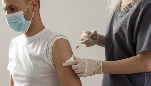 Läkare gör vaccinering i axeln av patient på ett sjukhus — Stockfoto
