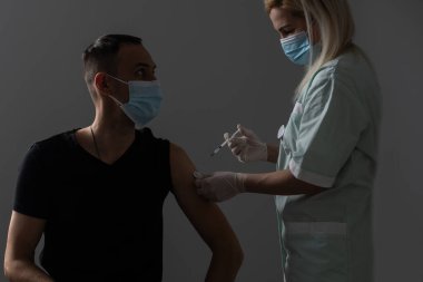 Doktor genç ve çekici bir adama aşı yapar. Covid 19 Coronavirus aşısı vurulur. Üçüncü aşı aşısı olur..