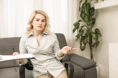 Terapi ofisinde panosu olan güzel bir kadın psikoloğun portresi.