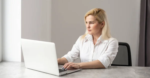 Снимок привлекательной деловой женщины, работающей на ноутбуке на рабочем месте . — стоковое фото