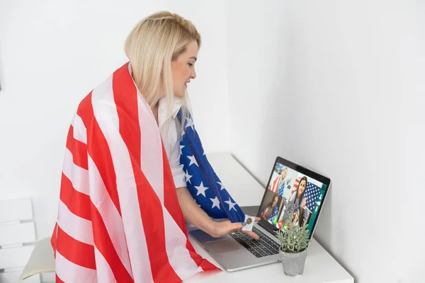 Jovem com bandeira dos EUA usando um computador portátil, dia da independência on-line — Fotografia de Stock