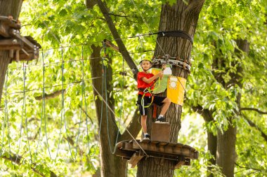 Tatlı çocuklar. Oğlan ve kız macera parkında ip parkına tırmanıyorlar.