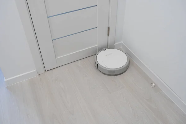 Ρομπότ ηλεκτρική σκούπα εκτελεί αυτόματο καθαρισμό του διαμερίσματος σε ένα ορισμένο χρονικό διάστημα. Έξυπνο σπίτι — Φωτογραφία Αρχείου