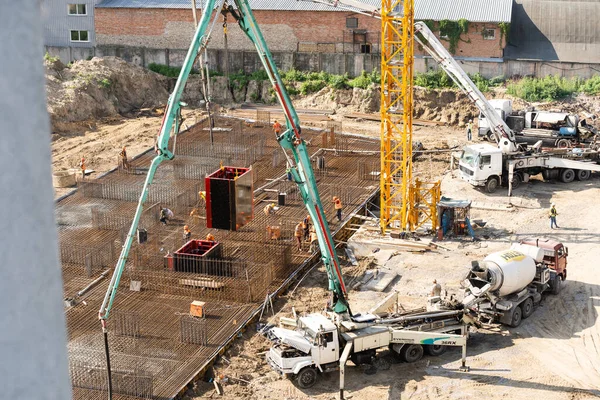 具体的な作業:コンクリート中の建設現場の労働者がスキップして建築面積に作業を注ぎ込み — ストック写真