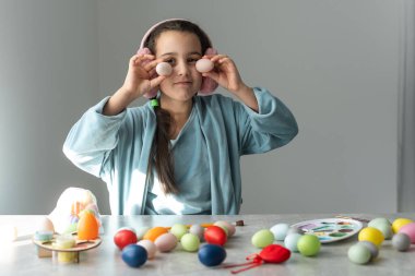 Paskalya bayramı kutlaması, tatlı kız, renkli yumurtaların yanında mutlu küçük çocuk, kalemler.