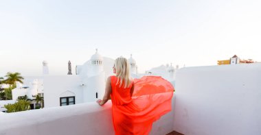 Denize bakan balkonda duran genç kız.