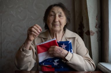 Amerikan bayrağı taşıyan, çok yaşlı bir Amerikalı olmaktan gurur duyan son sınıf öğrencisi..