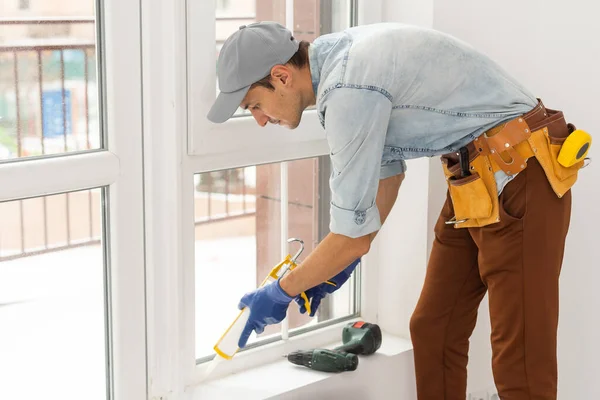 A man straightens a plastic window or door with a screwdriver. — Stock Photo, Image