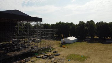 İşçiler bir konser sahnesi inşa ediyorlar. Yüksek binalar fikri işe yarıyor. metal tasarımları