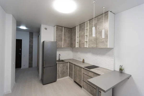 Cozinha moderna com mobiliário cinza e piso de madeira — Fotografia de Stock