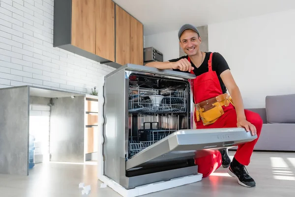Νέος επισκευαστής υπηρεσία εργαζόμενος επισκευή πλυντηρίου πιάτων συσκευή στην κουζίνα — Φωτογραφία Αρχείου