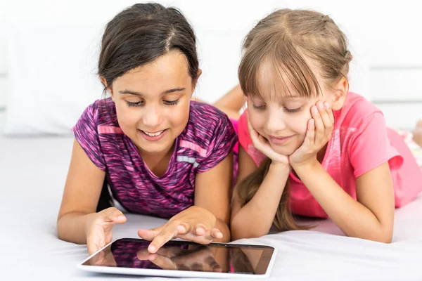 Personas, niños, tecnología, amigos y concepto de amistad - niñas que buscan Tablet PC en casa —  Fotos de Stock